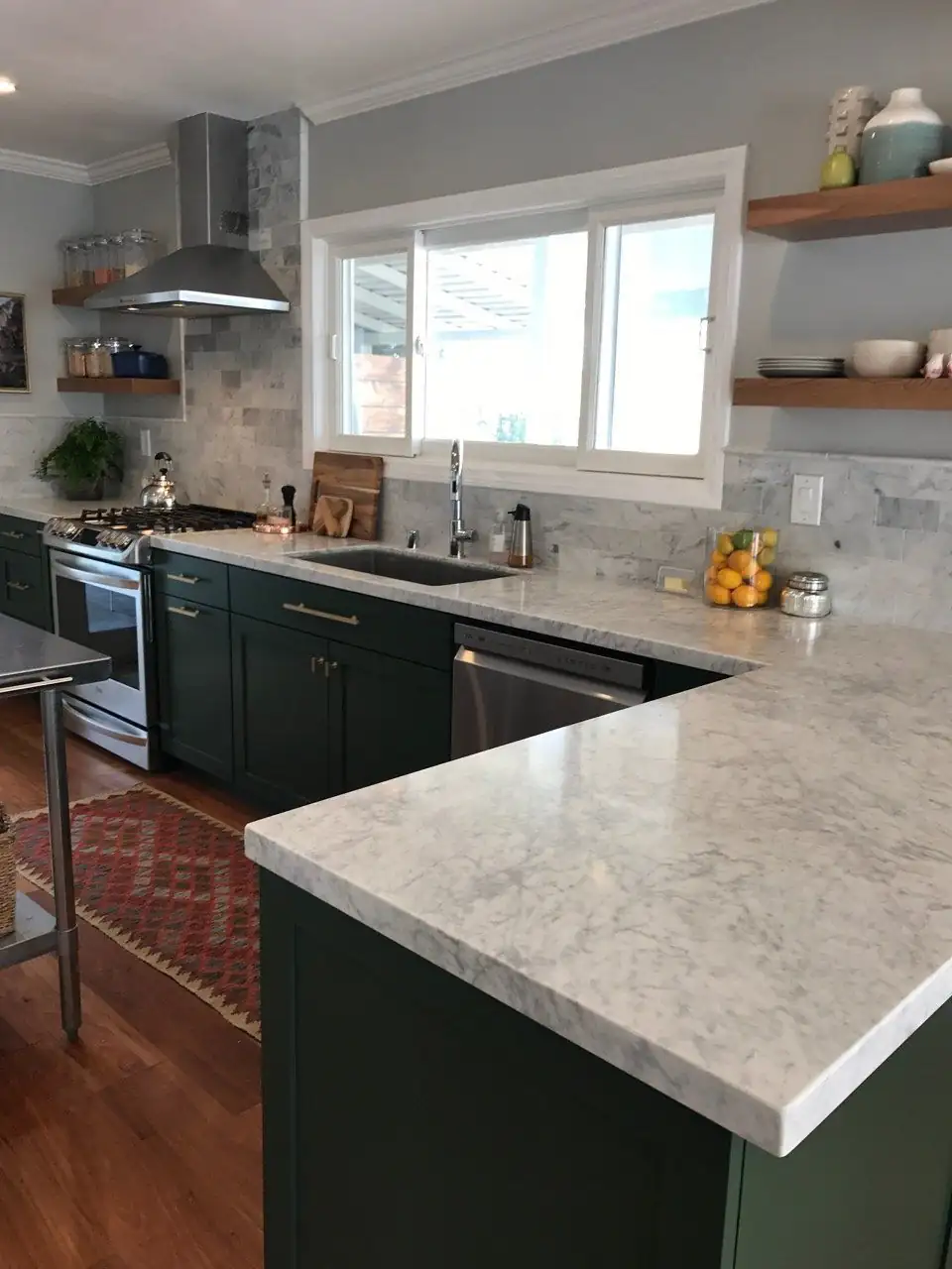 Deep green shaker cabinets, white marble counters and a marble subway backsplash in a kitchen by Rommy's, kitchen remodeling in Chula Vista, CA